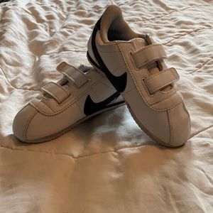 Toddler white Nike sneakers with black details. Size 10. Never worn.